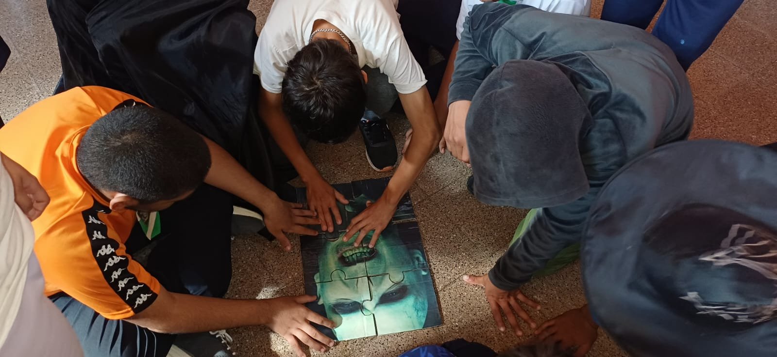 Estudiantes armando un rompecabezas en una actividad grupal